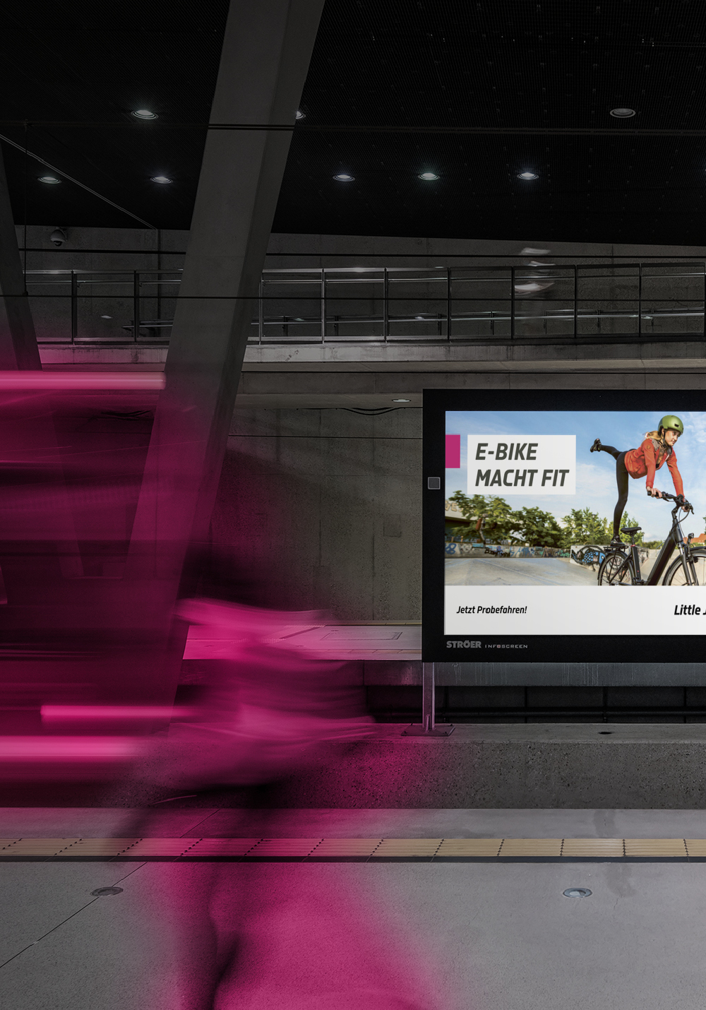 Werbeplakat von Little John Bikes in Großstadt an einem Bahnhof, dynamische Schrift, im Vordergrund verwischte Lichter von einem abfahrenden Zug
