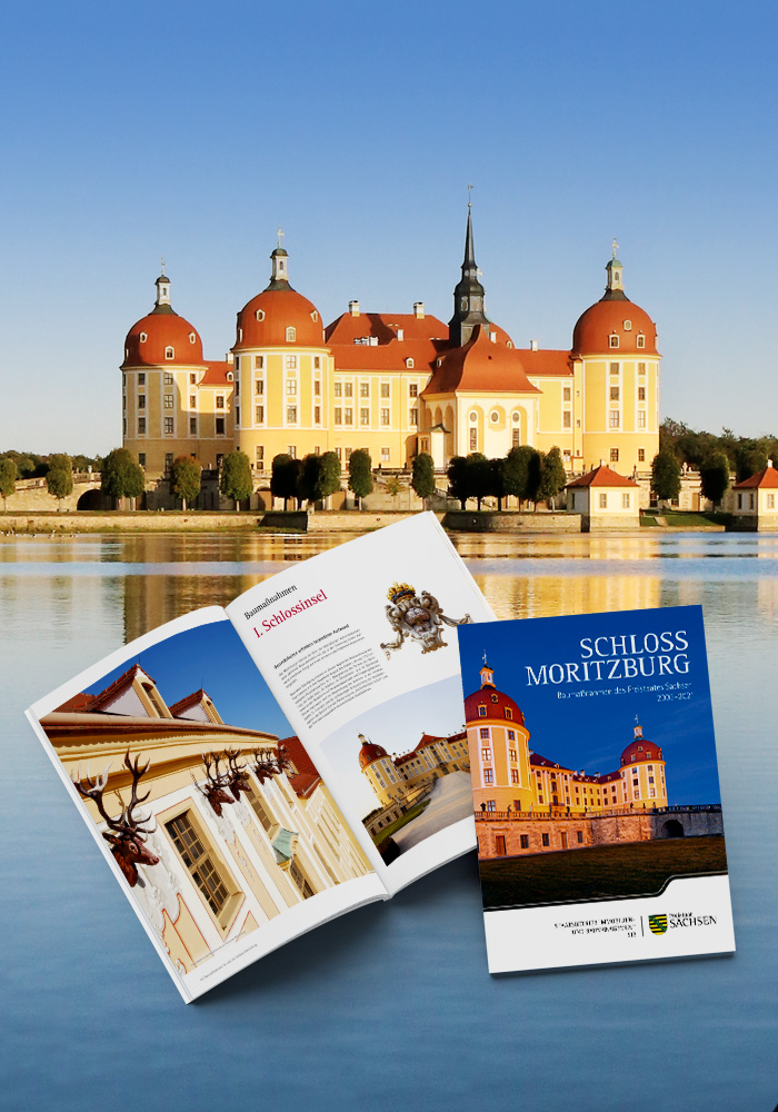 Aufgeschlagen Seiten und Cover der Broschüre „Schloss Moritzburg – Baumaßnahmen des Freistaates Sachsen 2003–2021“ platziert vor einem Foto des Schlosses